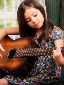 little girl learning guitar